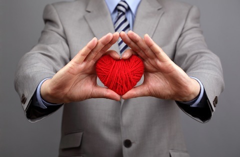 poslovni ljudi drže crveno srce