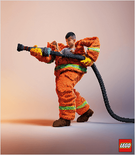 Ovo je fotografija iz LEGO oglasa koja prikazuje mladog azijskog dječaka u vatrogasnoj uniformi od LEGO-a. Uniforma je narančasta s neonsko zelenom prugom oko manšeta kaputa i hlača. Vatrogasac stoji jednom nogom unatrag i drži vatrogasnu dušu, također od legosa. Dječakova glava pojavljuje se s vrha uniforme, koja je puno veća od njega i zaustavlja se oko ramena. Fotografija je snimljena na običnoj neutralnoj pozadini. LEGO logotip pojavljuje se u crvenom okviru u donjem desnom dijelu. Talia Wolf kaže da je LEGO sjajan primjer marke koja koristi emocije u oglašavanju.